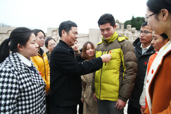 图为教科公司党委书记周友士为员工党员佩戴党徽。记者 戴云 摄.jpg 图为教科公司党委书记周友士为员工党员佩戴党徽。记者 戴云 摄.jpg